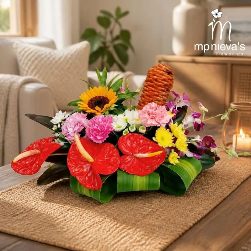 Tropicana memorial arrangement with red anthuriums, sunflower and pink carnations by MP Nieva's Flower Shop